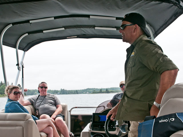 Tony Sampson of Salty Dog Sea Tours talking to guests of the Oak Island Fan Experience Tour, while on a boat tour of Oak Island.